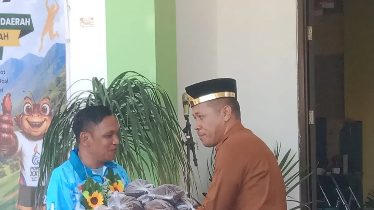 HANGAT: Kadis Pemerintahan Desa Kabupaten Buol, Arfandi Wehantow, saat memberi gula merah oleh-oleh khas Kabupaten Buol untuk kontingen POPDA Kabupaten Poso, yang telah tiba di Buol, pagi ini, Senin (24/8/2026).(FOTO: ISTIMEWA/RADAR PALU). 