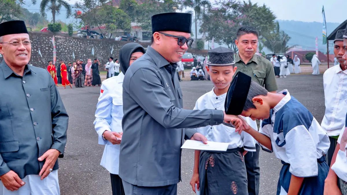 SANTUNAN: Bupati Morut Dr. dr. Delis Julkarson Hehi, MARS., dan Wakil Bupati H. Djira Kendjo S.Pd., M.Pd., menyalami santri sekaligus menyerahkan santunan dari Baznas usai upacara peringatan Hari Santri Nasional 2026 di pelataran Kantor Bupati Morut, Kamis (22/10/2026). (FOTO: ISTIMEWA/RADAR PALU)
