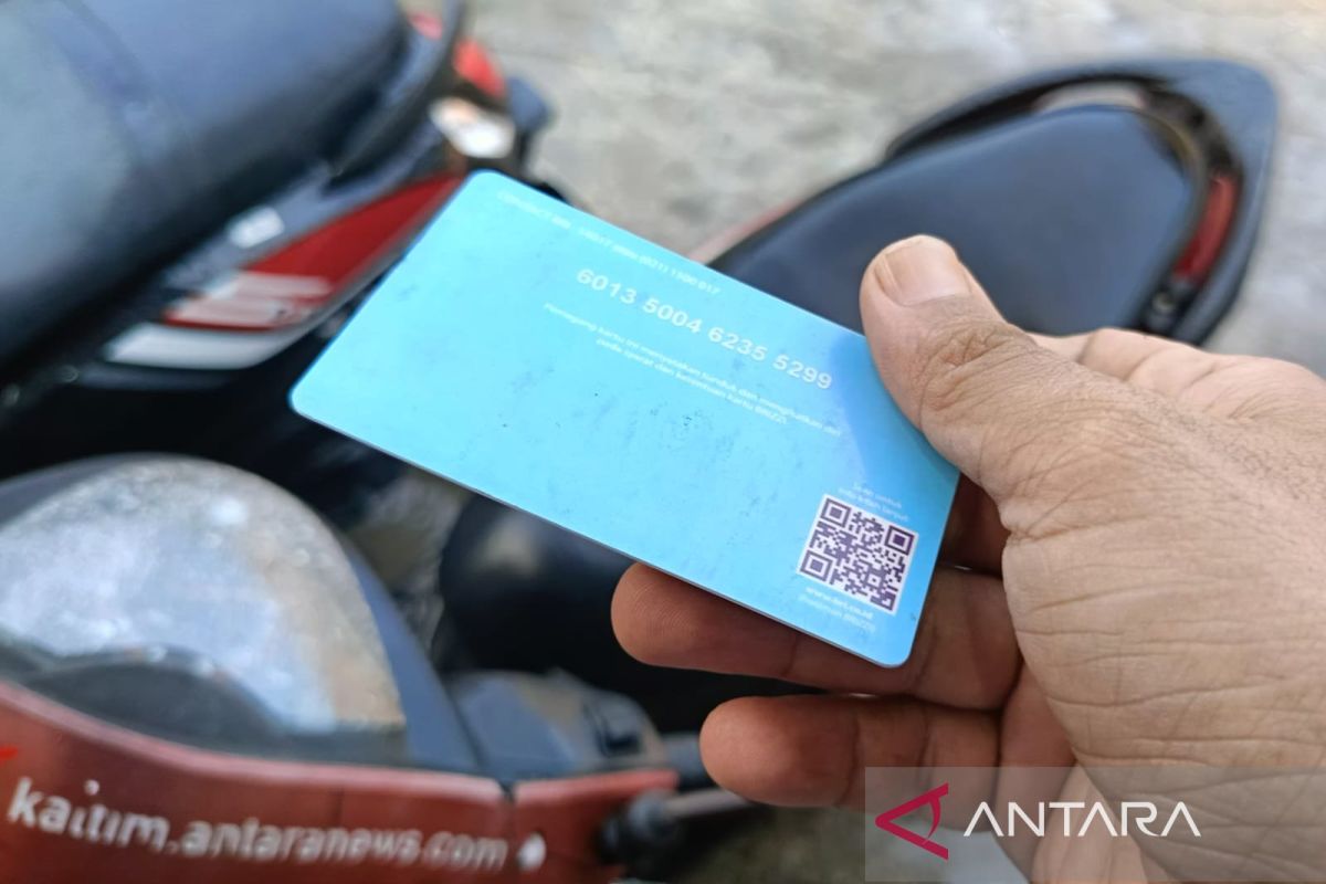 Tap kartu elektronik di mesin parkir otomatis .