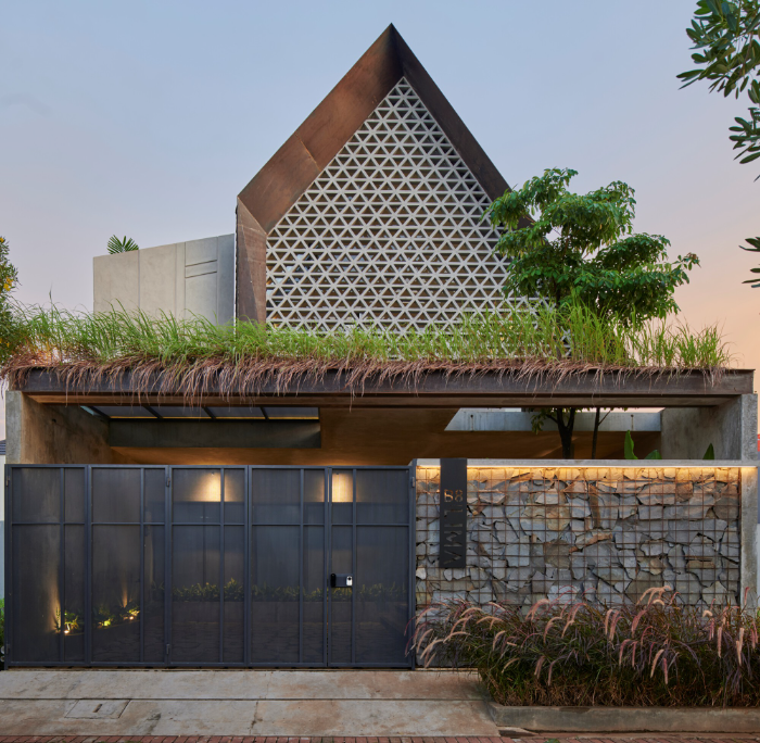 Desain rumah klasik Indonesia dengan atap joglo khas dan ukiran pintu yang rumit, mencerminkan warisan budaya Nusantara.  Keywords: