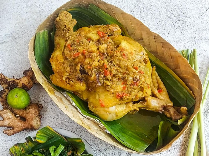Ayam Betutu khas Bali disajikan dengan nasi panas, sambal matah, dan plecing kangkung. Bumbu rempah melimpah bikin nagih!