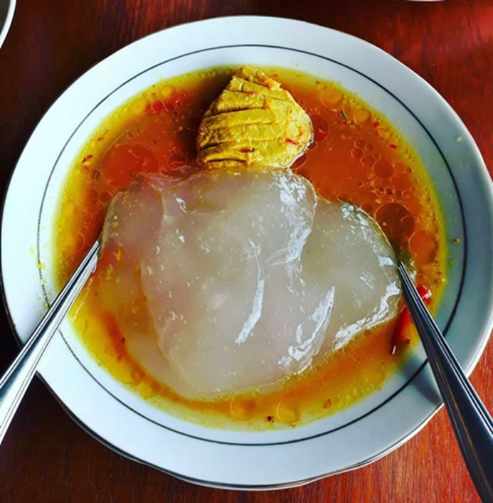 Sepiring Papeda dengan ikan kuah kuning dan daun melinjo, makanan khas Papua yang lezat dan unik.
