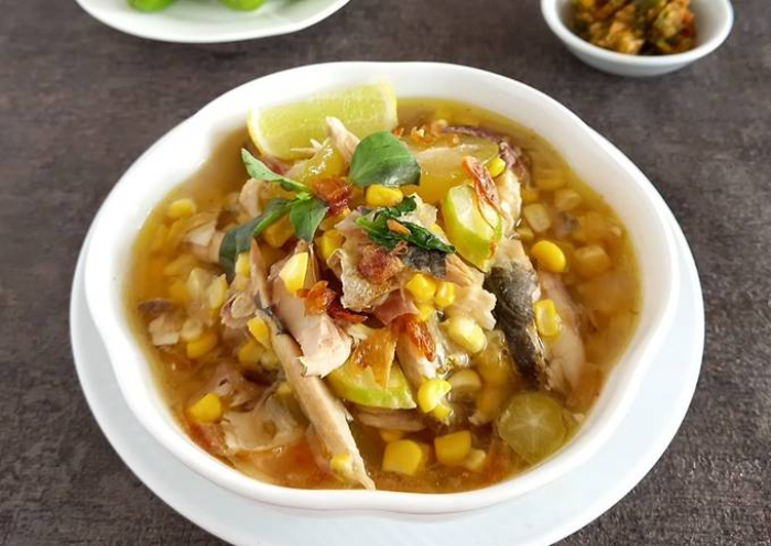 Semangkuk Binte Biluhuta dengan jagung manis, tomat segar, dan kelapa parut, khas Gorontalo.