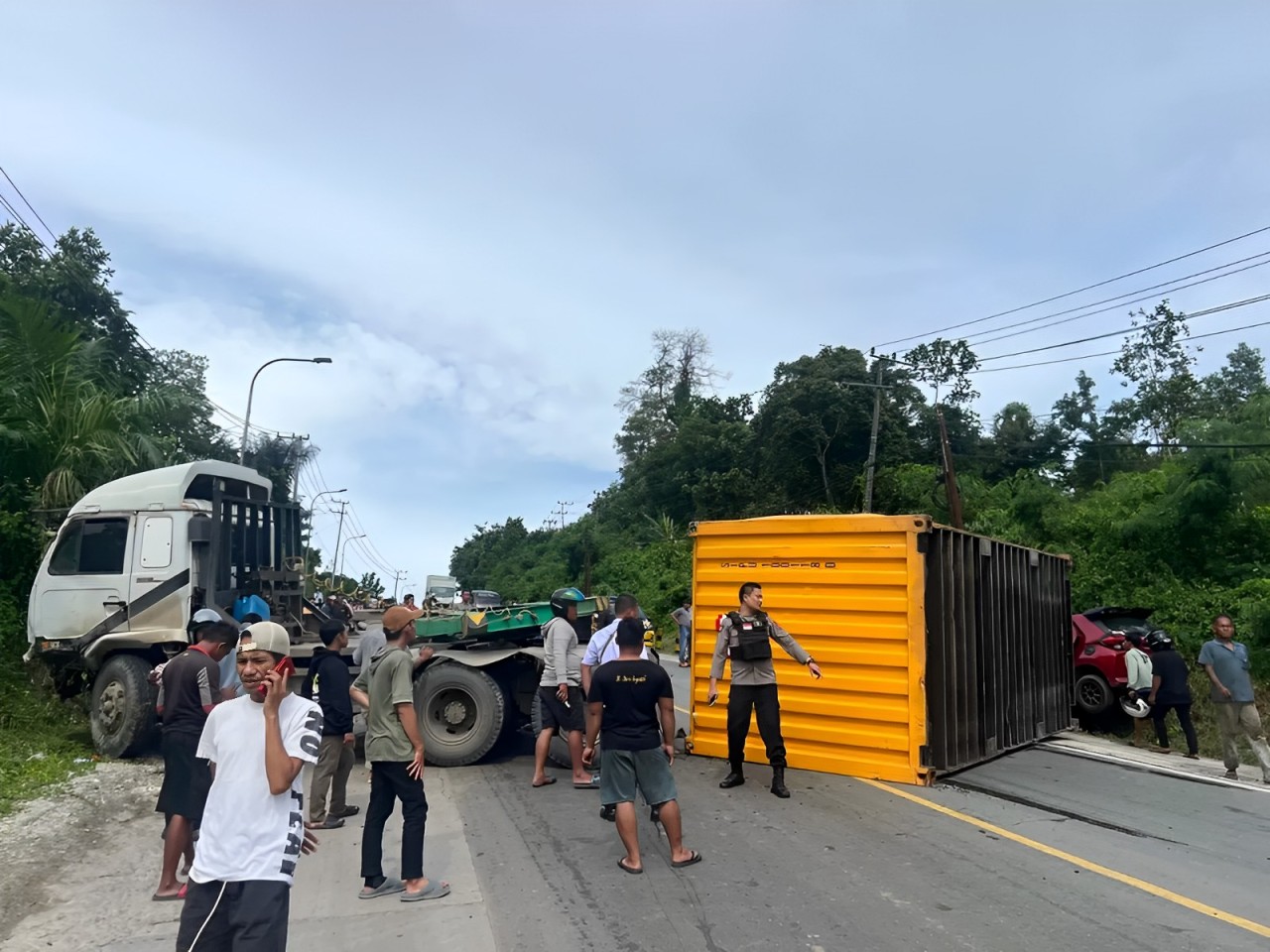 Gambar truk kontainer melintang di jalan Poros Samarinda Bontang, menutup jalan, menyebabkan kemacetan panjang. Simak info lengkapnya hanya di BalikpapanTv.id!