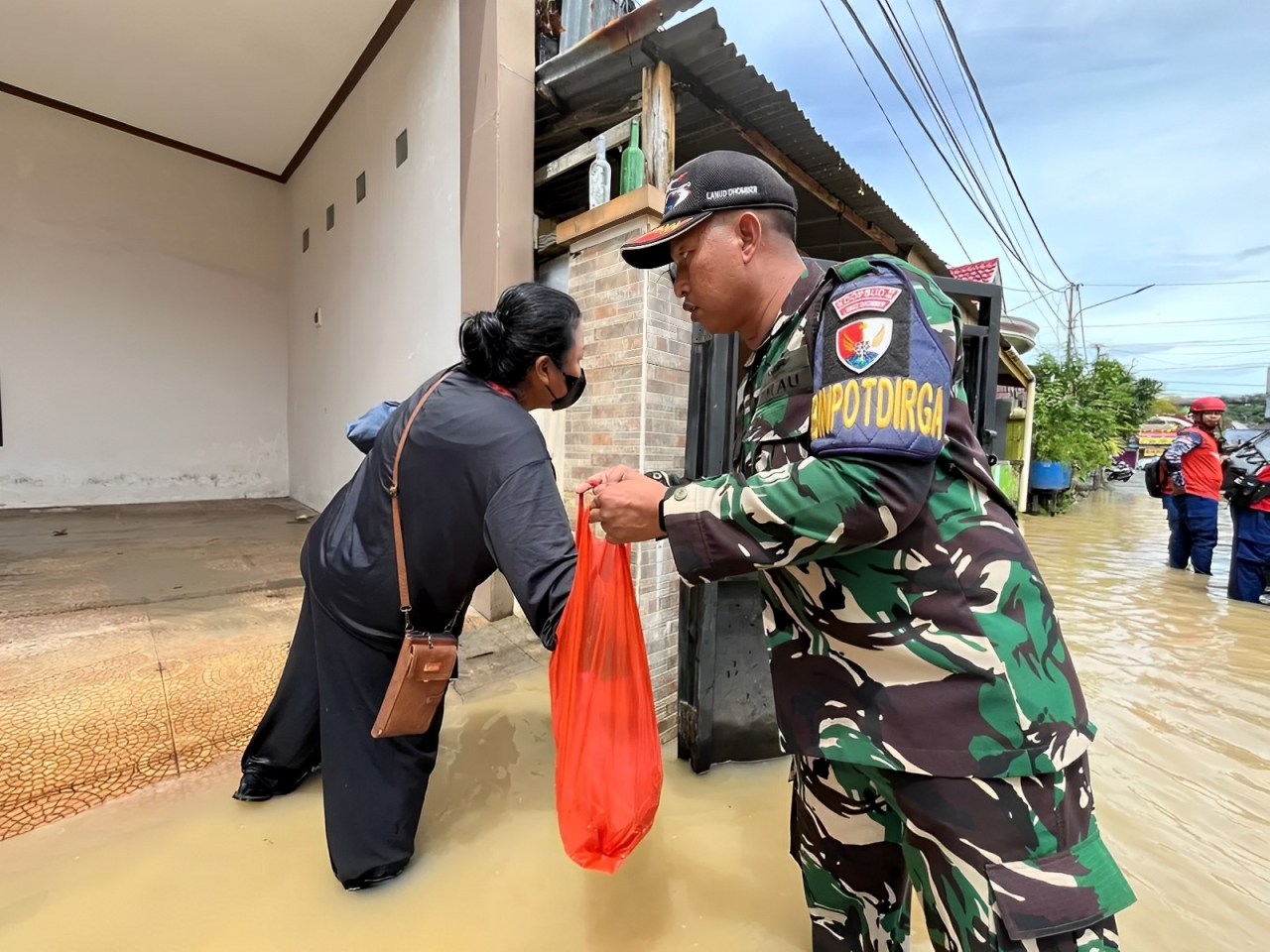 Petugas membagikan makanan bagi warga di Gang Mufakat II.