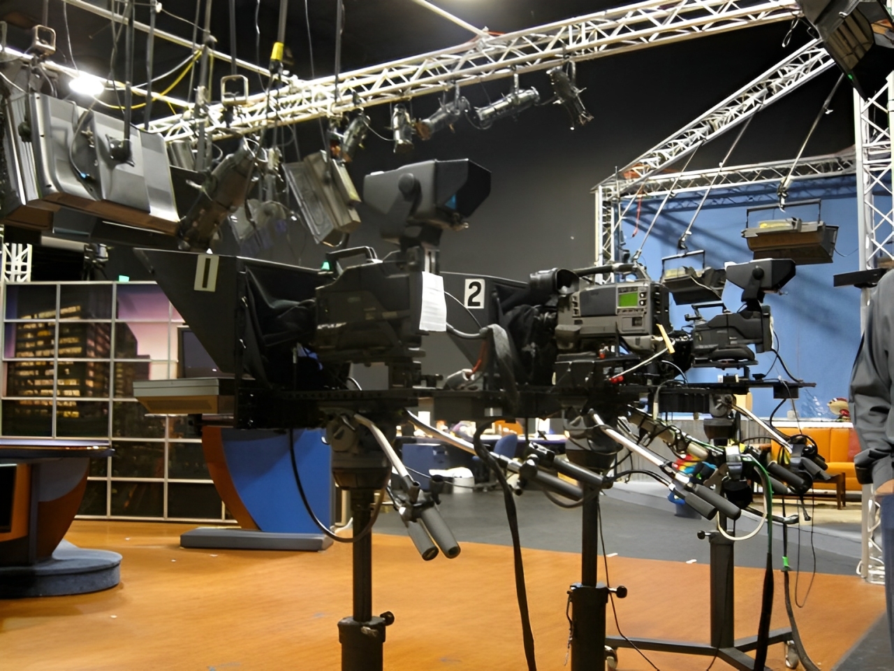 Ilustrasi tim produksi live streaming televisi bekerja di control room saat program berita berlangsung. Dilengkapi keyword live streaming berita, tim produksi televisi, dan pekerjaan di balik layar.