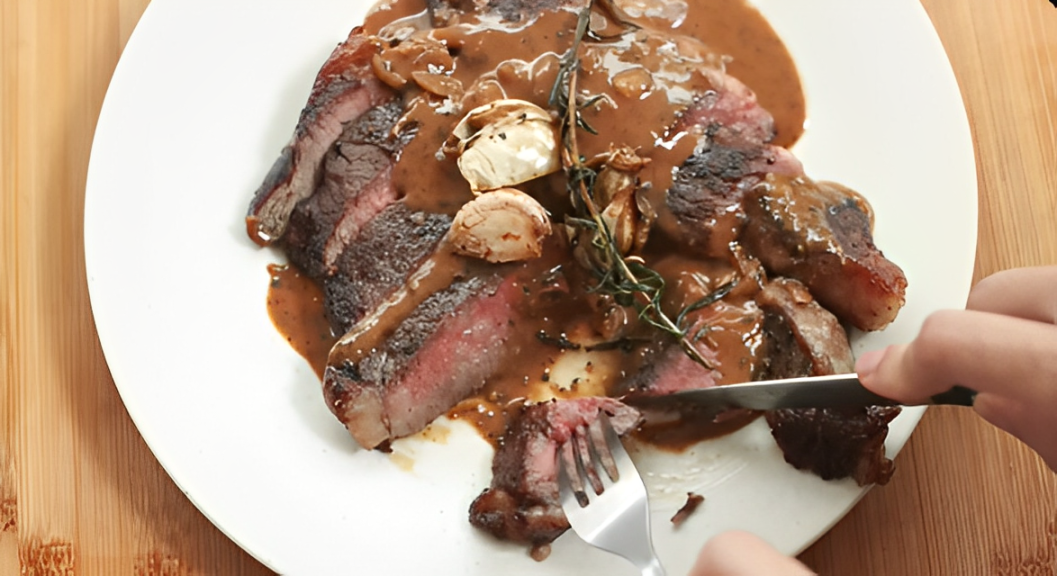 Chef Devina Hermawan mencicipi black pepper steak hasil masakannya.