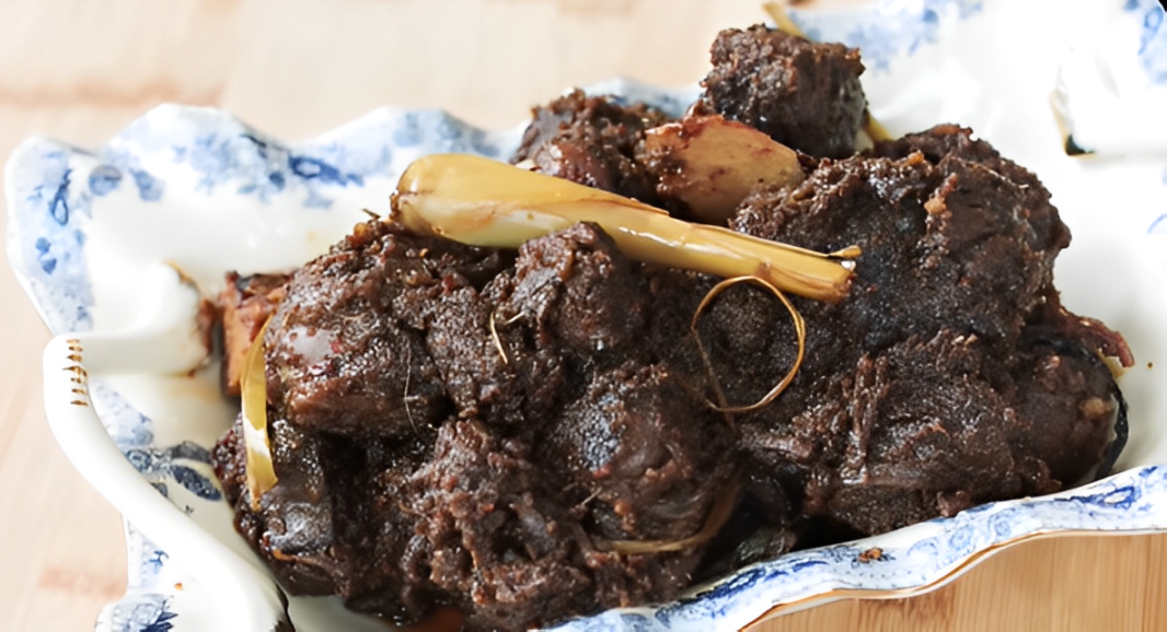 Tampilan rendang daging sapi khas Padang dengan bumbu pekat dan warna gelap menggoda.
