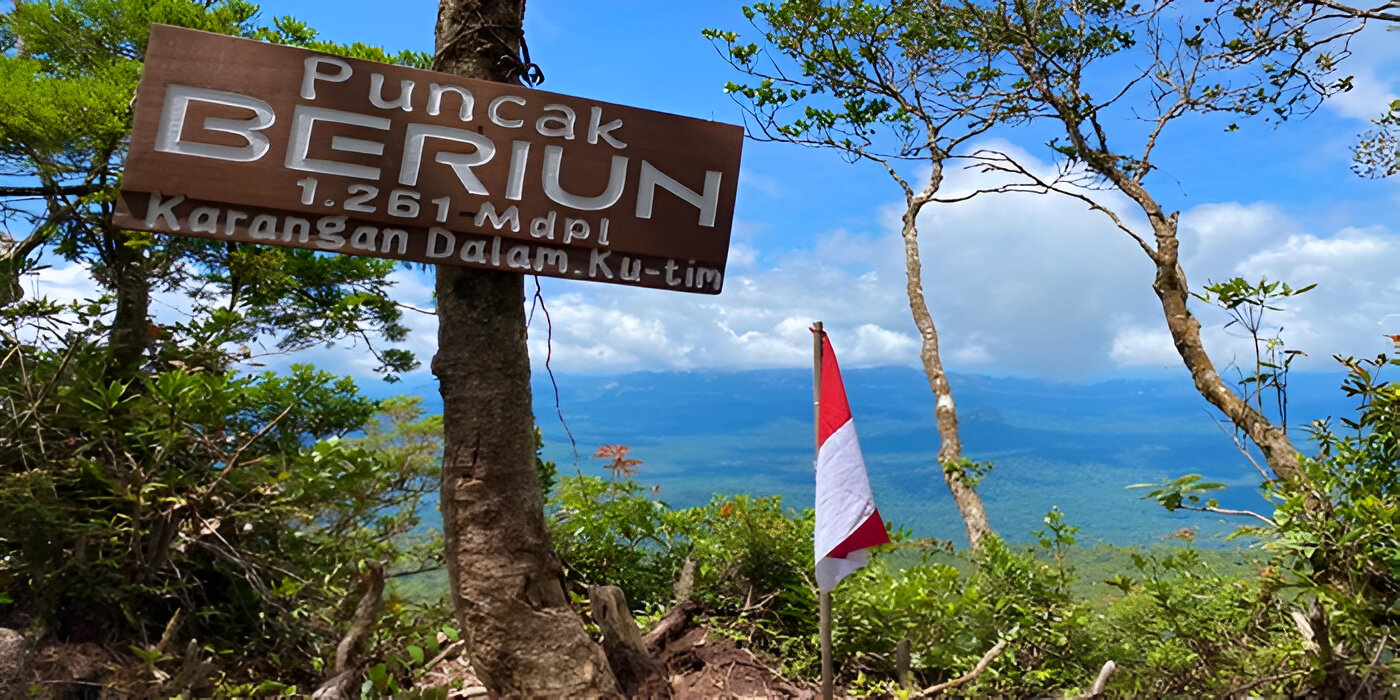 Puncak Gunung Beriun dengan latar panorama Pegunungan Karst dan hutan tropis Kalimantan Timur.