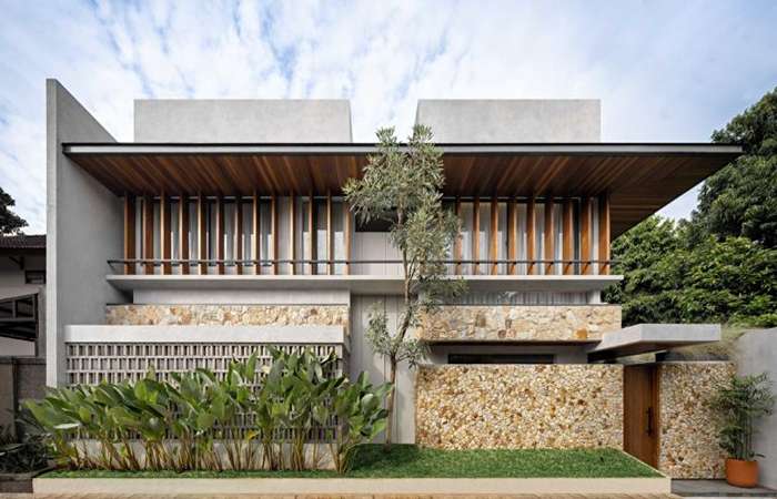 Foto rumah minimalis batu alam dengan fasad natural yang unik dan elegan, cocok untuk hunian minimalis bernilai tinggi.