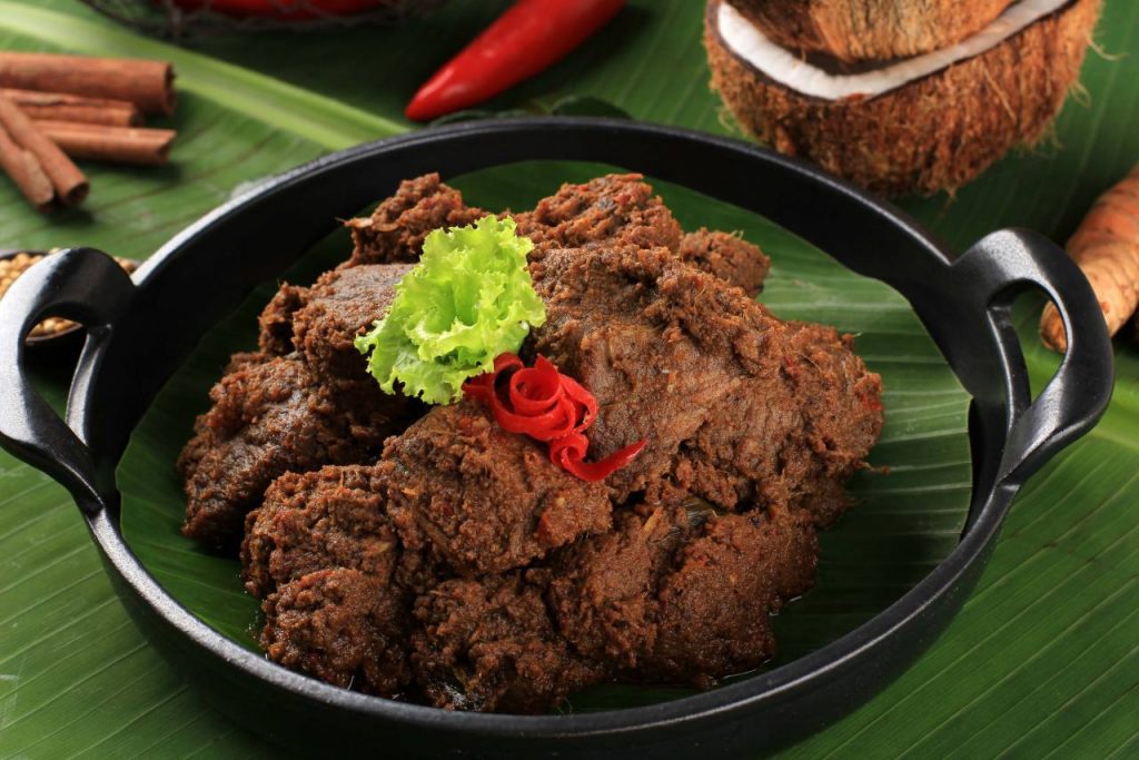 Foto rendang daging empuk khas Minang dengan bumbu pekat kecokelatan, santan dan rempah lengkap, menghadirkan cita rasa Nusantara autentik.