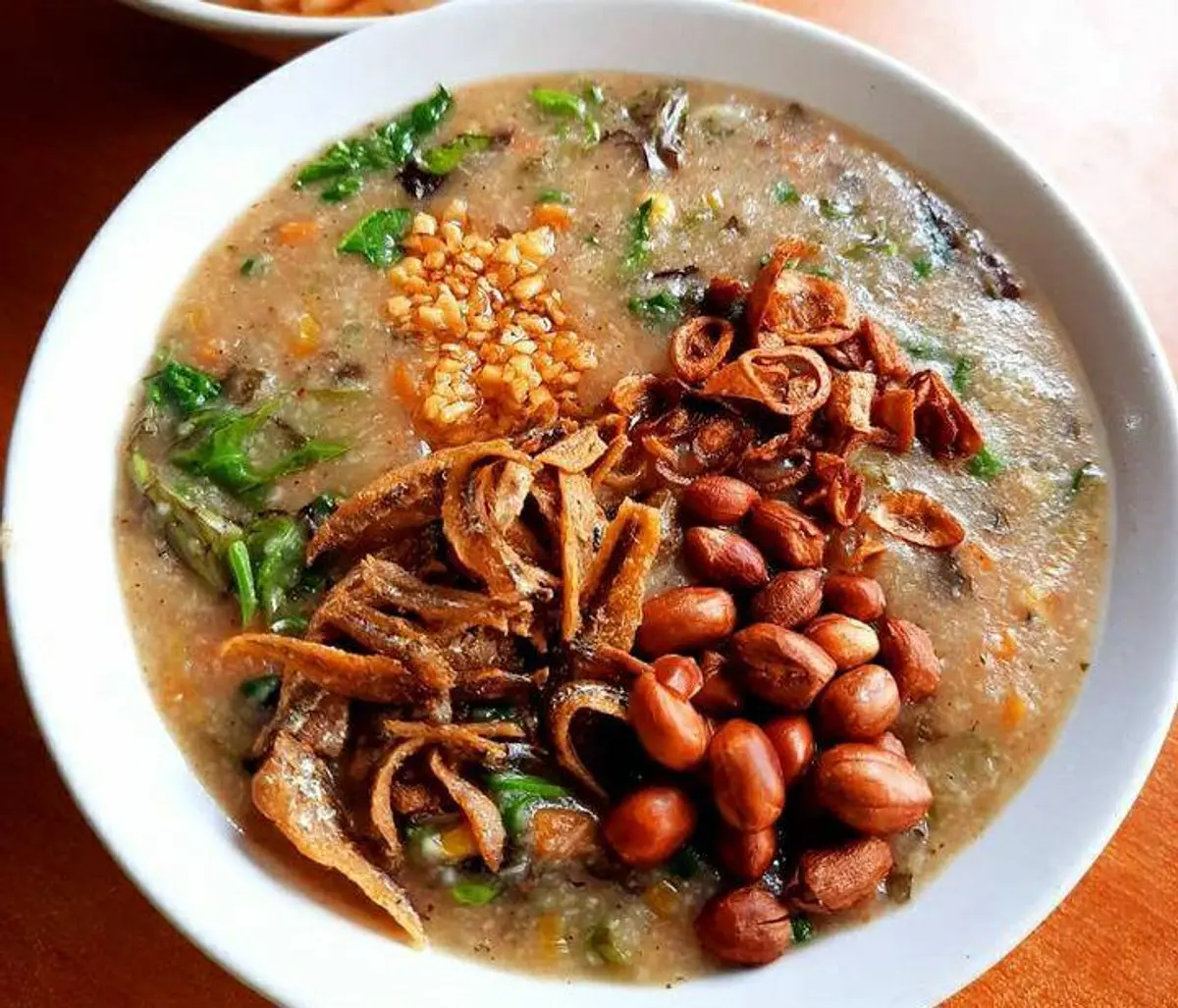 Foto bubur pedas Kalimantan dengan warna rempah alami, sayuran segar, dan pelengkap tradisional yang menggoda selera.