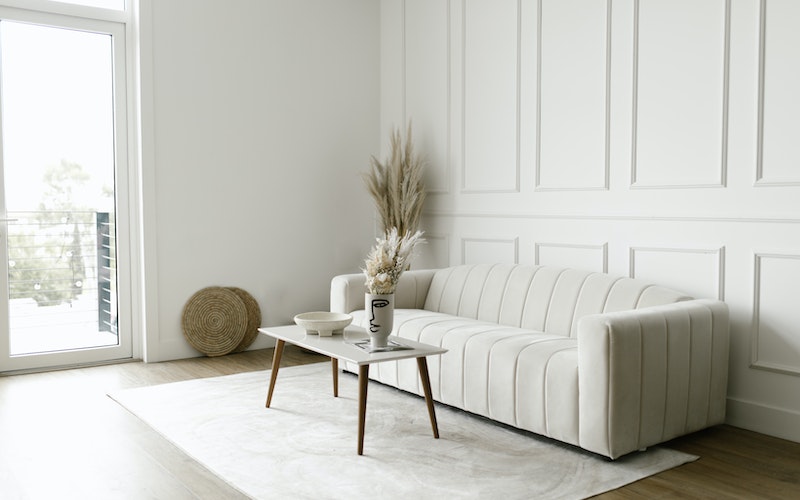Foto dekorasi ruang tamu estetik dengan palet netral hangat, sofa modular, layering tekstur, dan pencahayaan hangat Instagramable.