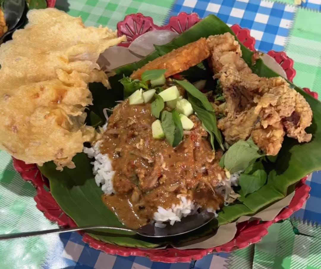 Sepiring nasi pecel Balikpapan dengan sayuran segar, bumbu kacang melimpah, peyek garing, dan lauk ayam krispi khas Nasi Pecel Pahiri.