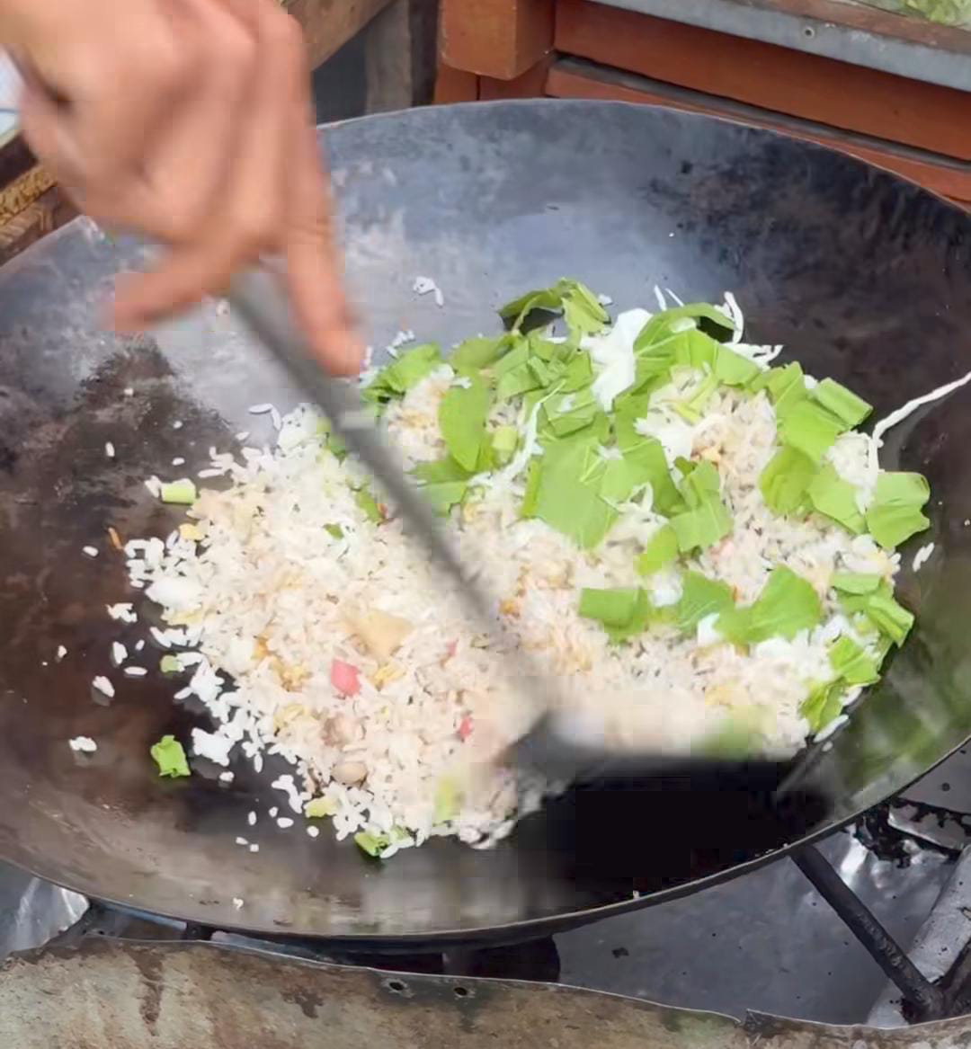 Suasana malam di warung Nasi Goreng Krenteng Koi Balikpapan, wajan besar mengepul, aroma nasi goreng khas yang menggoda selera.