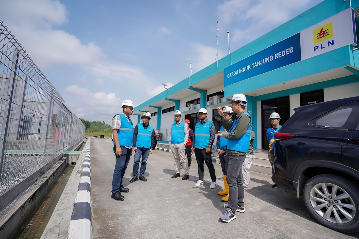 Pekerja PLN meninjau jalur SUTT 150 kV Kaltim-Kaltara, simbol persatuan dan semangat Pancasila untuk listrik andal dan efisien.