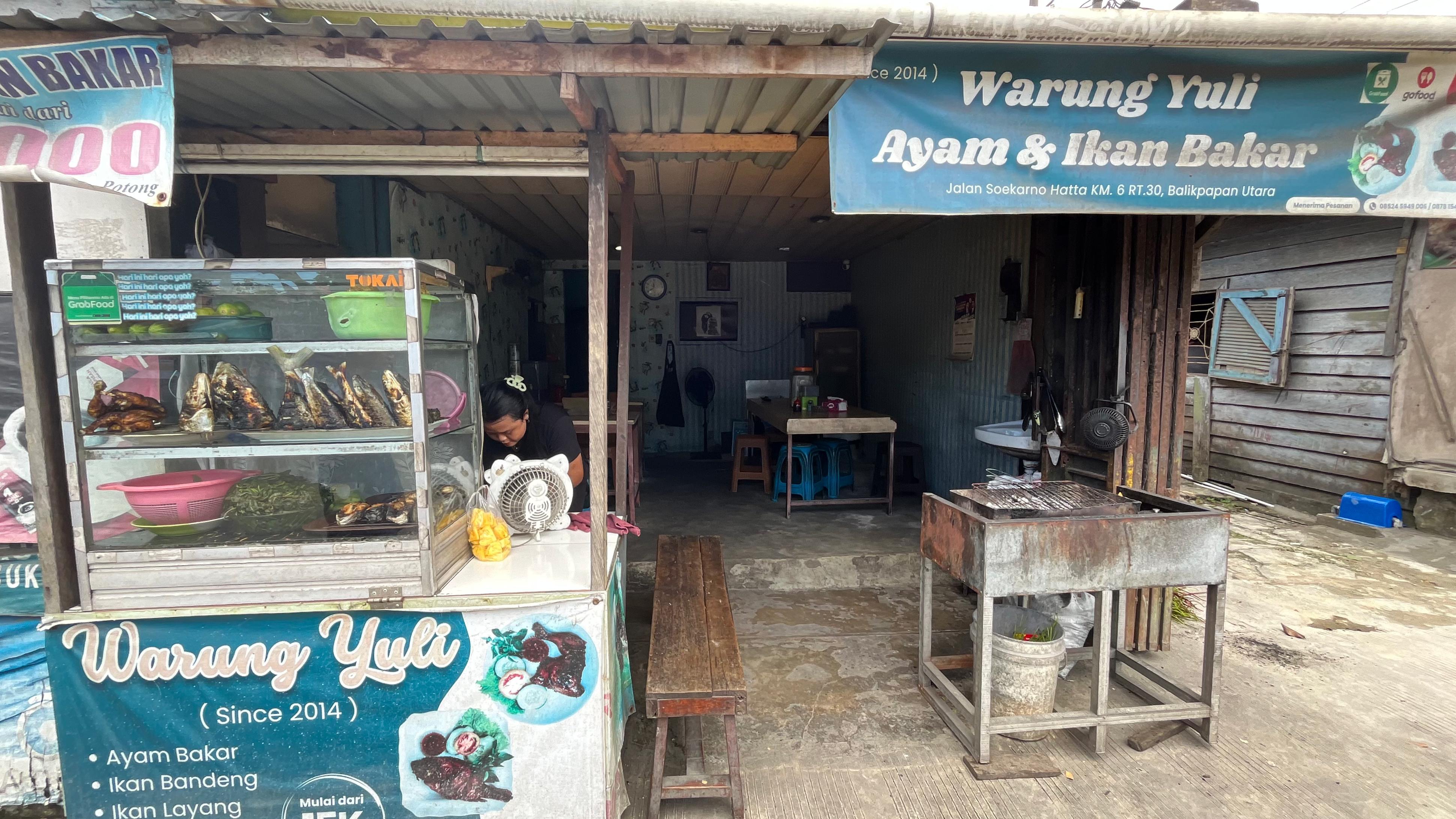 Tante penjual lalapan di Km 6 Balikpapan sedang menyiapkan menu bakaran khas warisan keluarga yang murah dan lezat.