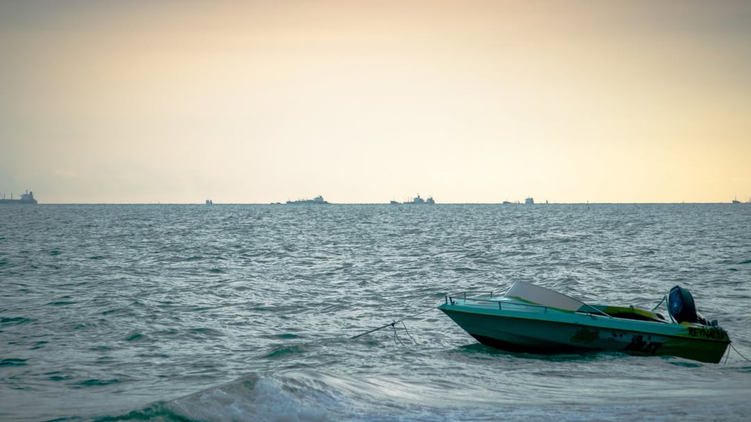 Pemandangan Pantai Lamaru Balikpapan yang tenang dengan hamparan pasir lembut, pohon cemara, dan suasana liburan santai &mdash; destinasi wisata alam favorit warga Balikpapan.