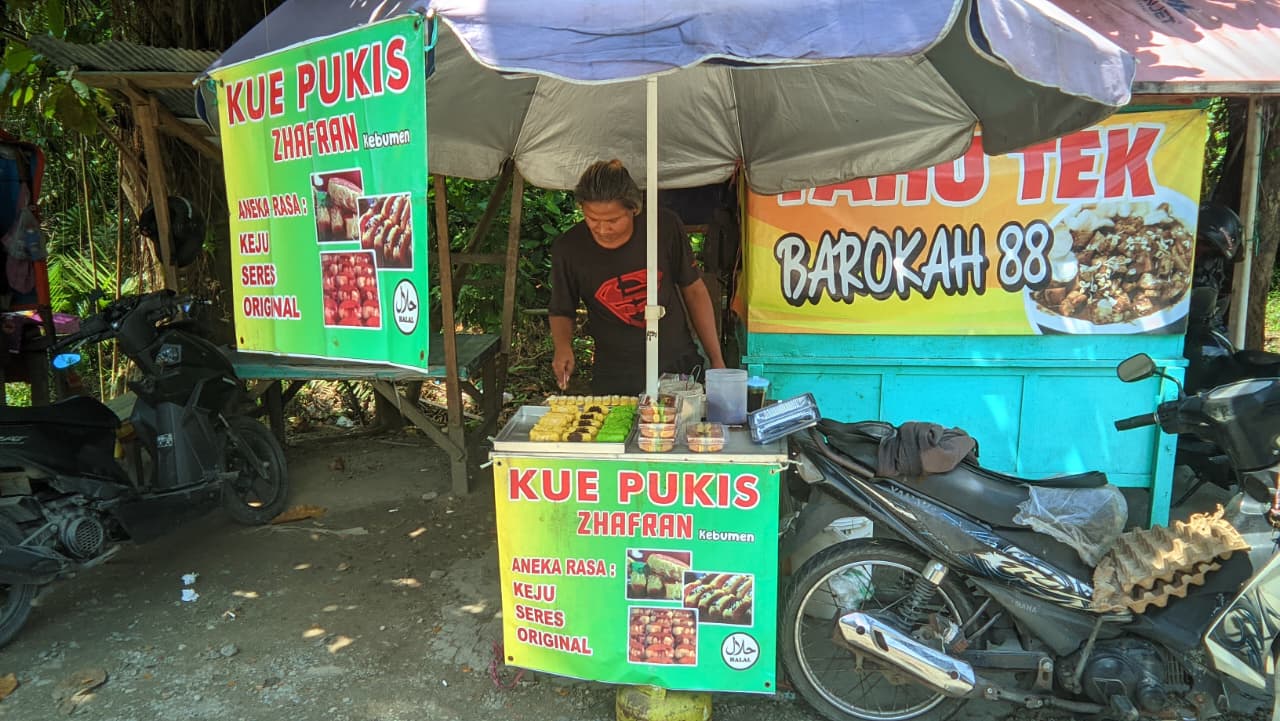 Penjual kue pukis di Jalan Kojakal sedang memanggang pukis hangat dengan aneka rasa, simbol semangat usaha kecil yang inspiratif dan penuh makna.