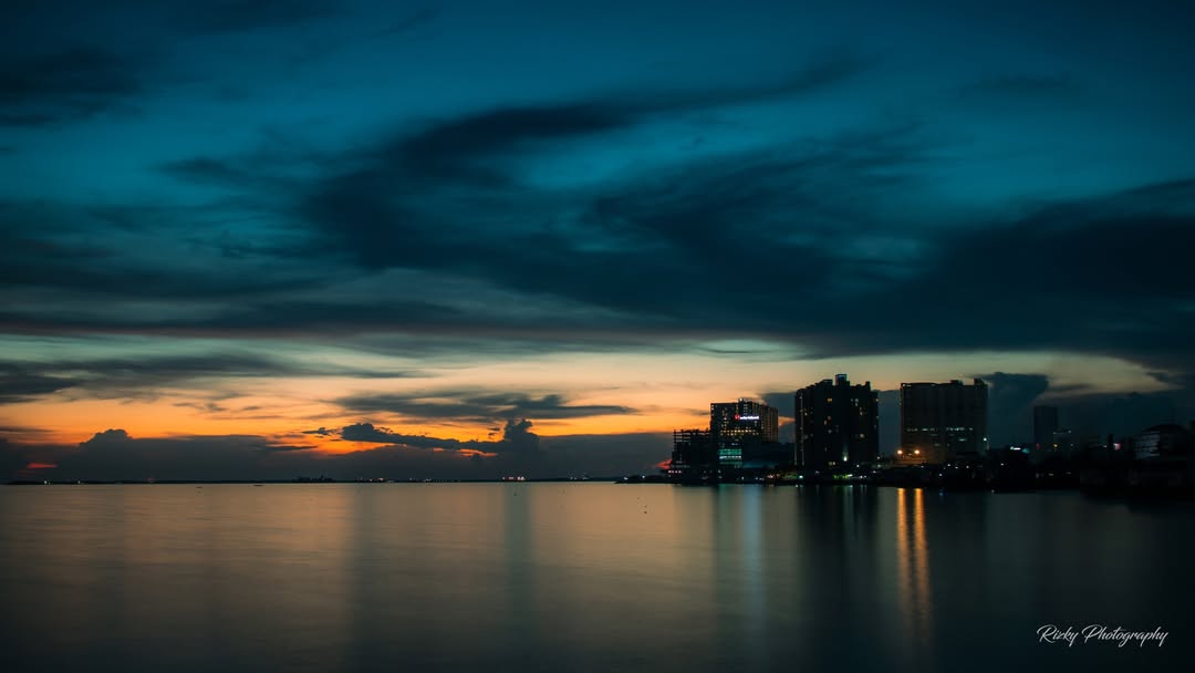 Suasana sore di Pantai Dusit Balikpapan dengan pasir putih dan sunset indah, destinasi healing alami di tengah kota.