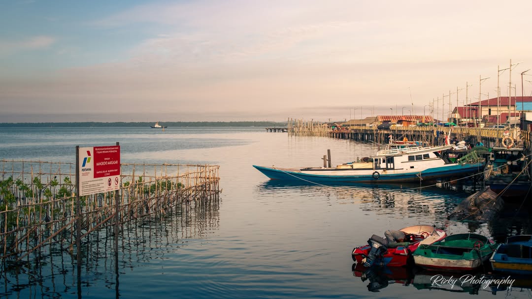 Pemandangan Kampung Atas Air Margasari Balikpapan saat senja &mdash; suasana tepi laut penuh warna yang memancarkan semangat baru warga kampung.