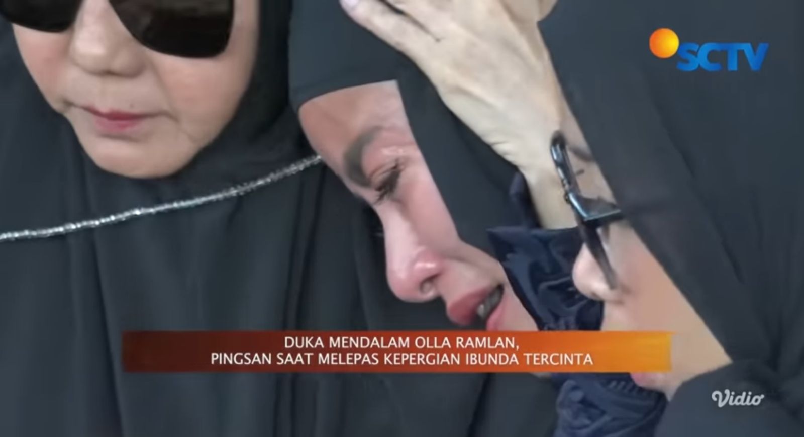 Olla Ramlan menatap liang lahat ibunda dengan air mata menetes &mdash; visual duka yang penuh cinta dan kehilangan mendalam.