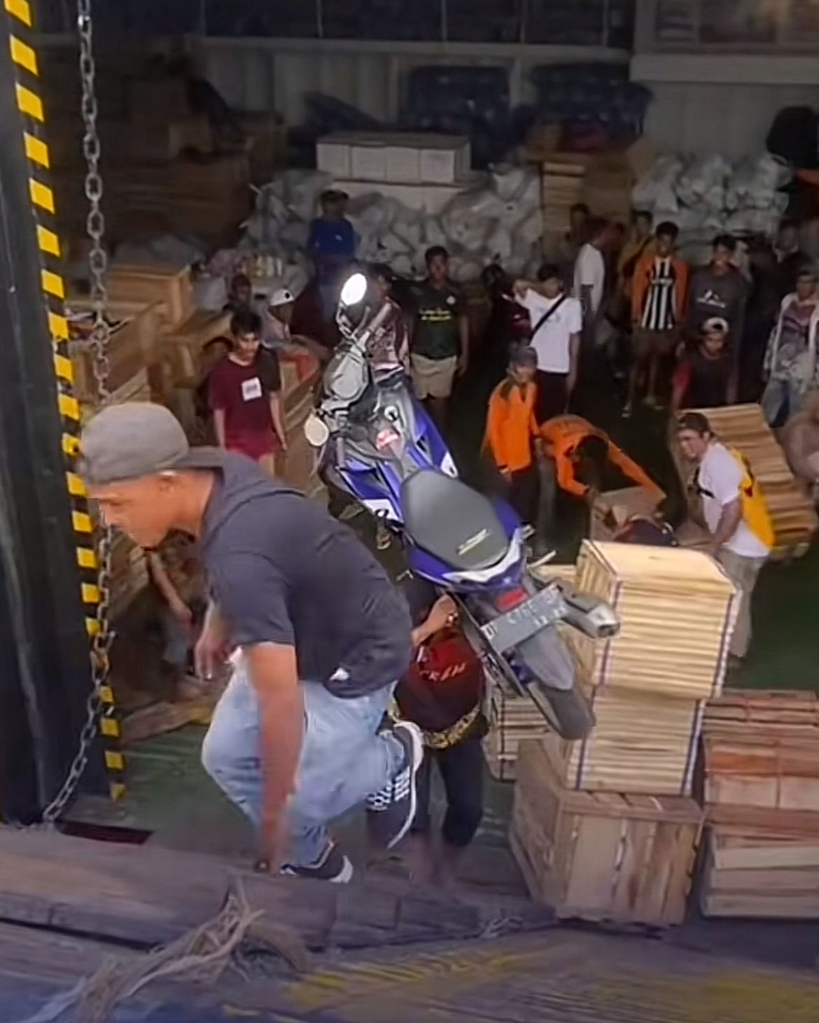 Seorang pria memanggul motor dari kapal &mdash; simbol cinta ayah dan semangat pejuang rupiah yang menyentuh hati.