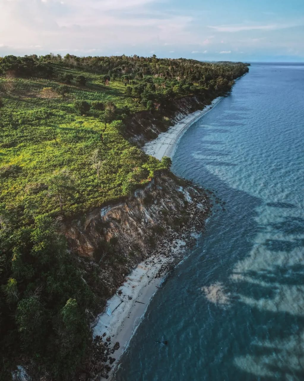 Tebing alami Pantai Tebing Runtuh Samboja &ndash; panorama laut biru dan tebing dramatis yang jadi magnet visual bagi wisatawan.