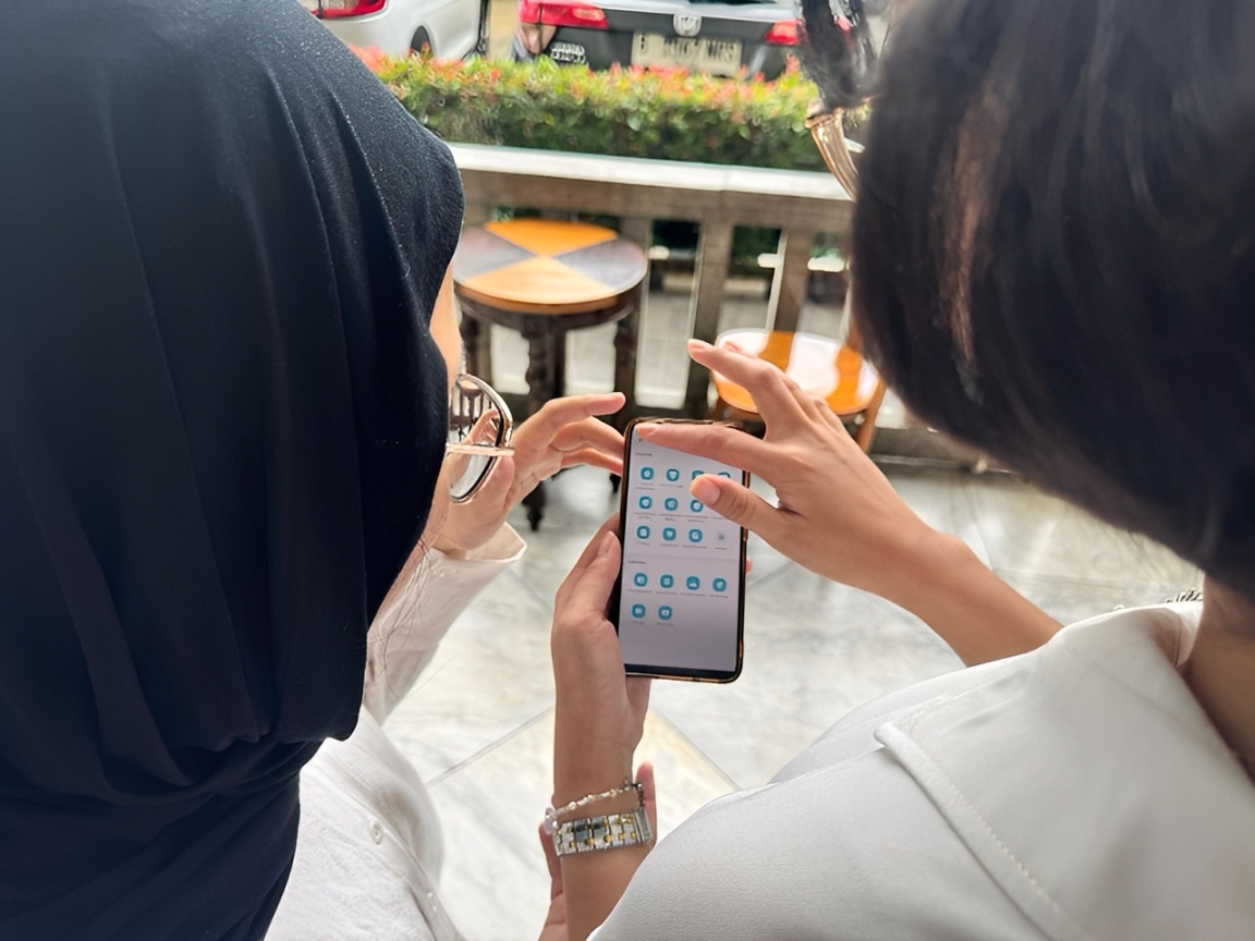 Pelanggan PLN tersenyum saat mengajukan tambah daya lewat aplikasi PLN Mobile.