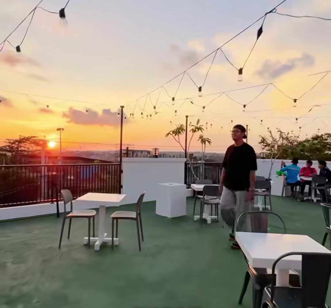 View sore dari rooftop Royce Coffee Balikpapan &mdash; golden hour yang memadukan kopi hangat dan langit oranye, sempurna buat healing visual.