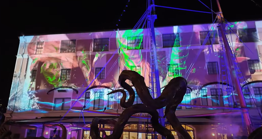 Pemandangan malam Halloween di Liseberg dengan coaster Helix berlampu neon, penuh kabut dan dekorasi labu oranye yang memesona.