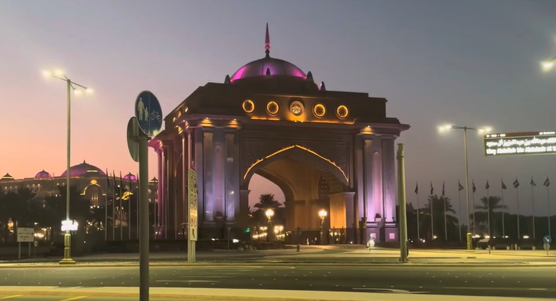 Pemandangan sunset di Abu Dhabi Corniche dengan siluet keluarga berjalan santai