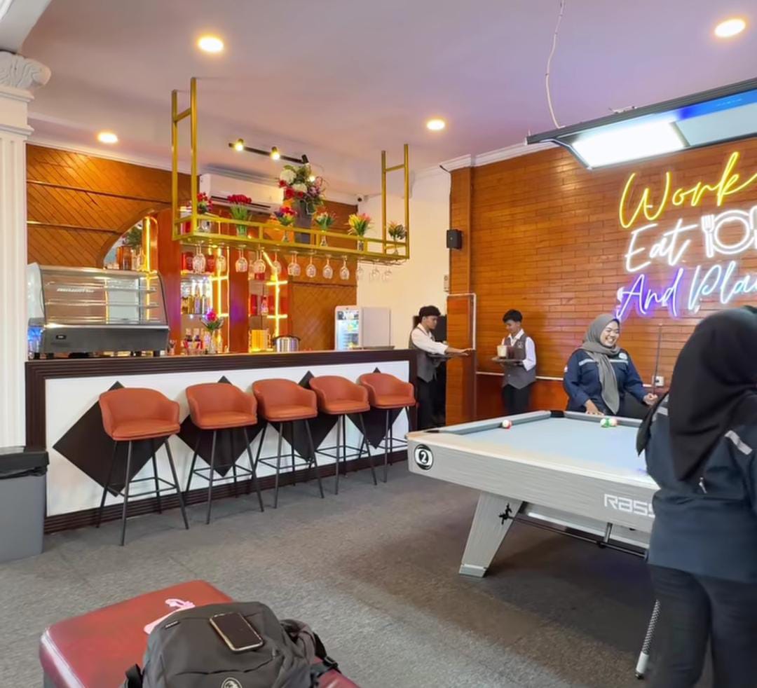 Suasana hangat Cross Street Caf&eacute; Balikpapan dengan interior modern, meja billiard, pengunjung asyik nongkrong