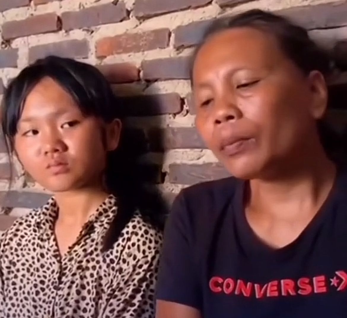 Gina Dwi Sartika duduk di depan rumah kontrakan bersama ibunya &mdash; potret keheningan yang bercerita tentang keteguhan dan harapan di balik luka sosial.