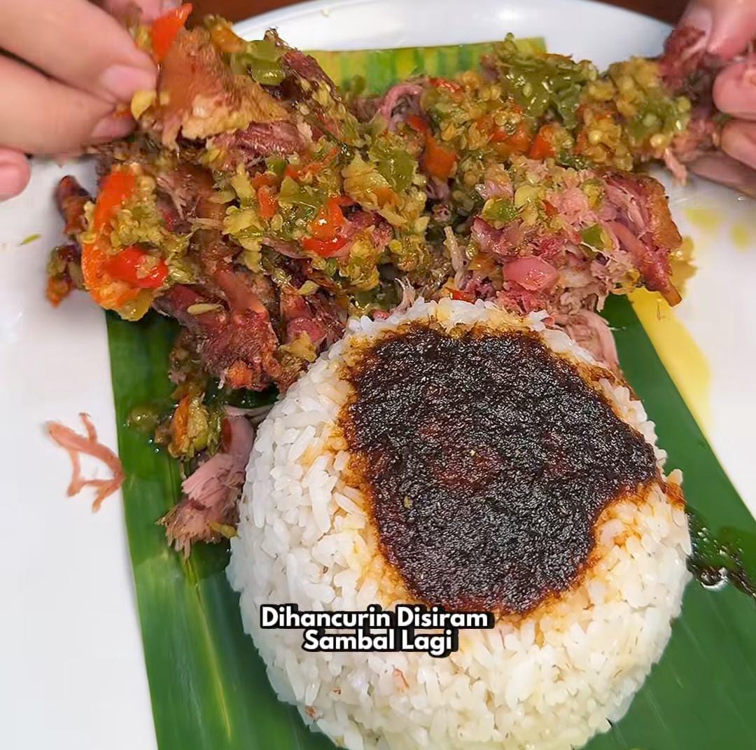 Potret sepiring bebek ancur Madura dengan sambal dan bumbu hitam khas, siap menggoda mata dan selera.