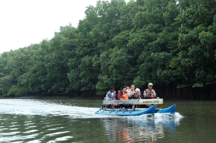 Wisata Balikpapan: Perahu kelotok di Sungai Somber &mdash; refleksi alami antara hijau mangrove dan air yang menenangkan.