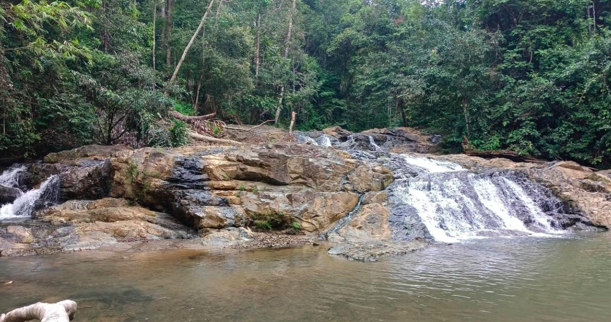 Panorama Air Terjun Doyam Turu Liang Batulis &mdash; air jatuh di antara tebing hijau, memantulkan cahaya pagi yang damai.