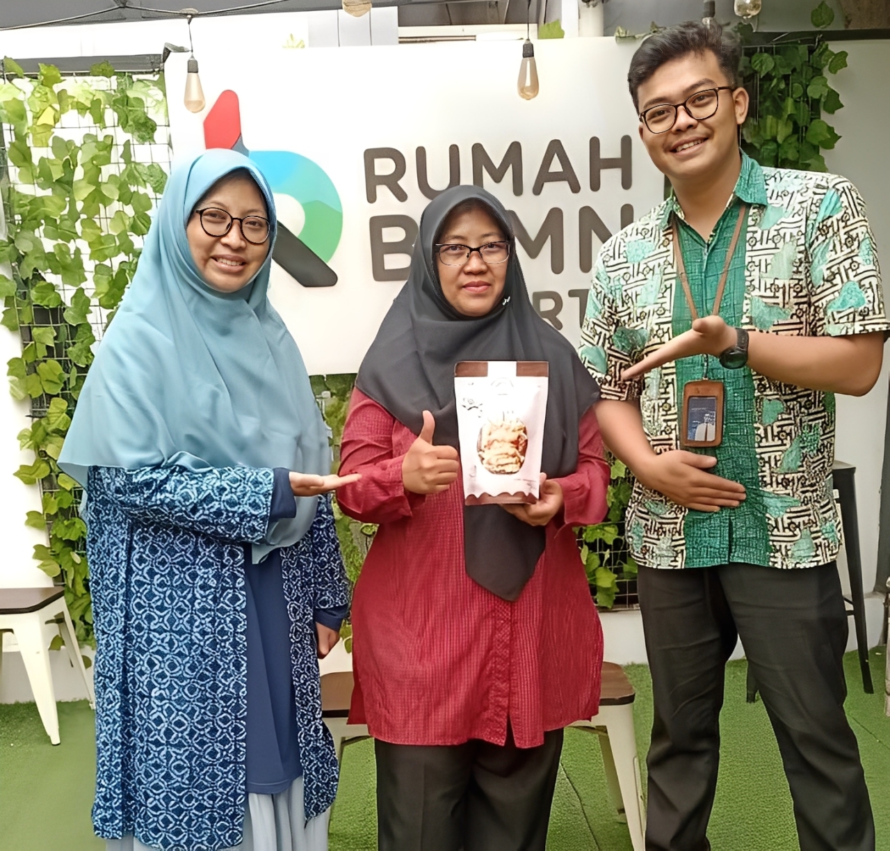 Pemilik usaha Bakulis bersama pendamping dari Rumah BUMN BRI Jakarta saat memperkenalkan salah satu produk kue kering hasil produksinya.