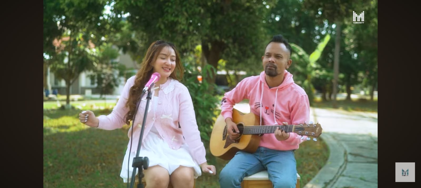 YUMEINITY bernyanyi dalam nuansa lembut, menciptakan visual hangat yang menggambarkan cinta yang belum terucap.