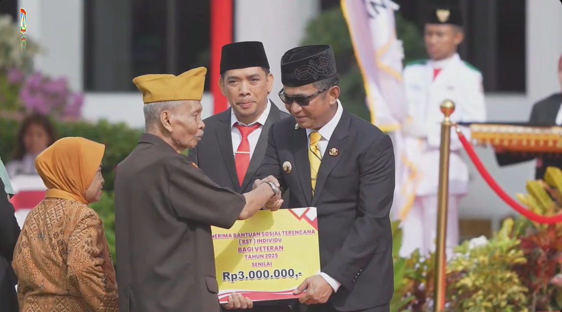 Wali Kota Balikpapan, Rahmad Masud, menyerahkan bantuan sosial kepada seorang veteran pada rangkaian upacara Hari Pahlawan di halaman Gedung Putih Balai Kota Balikpapan, Senin (10 November 2025).