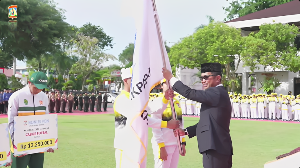 Wali Kota Balikpapan Rahmad Masud menyerahkan bendera sebagai tanda pelepasan kontingen pada Upacara Hari Pahlawan di halaman Gedung Putih Balai Kota Balikpapan, Senin (10 November 2025).
