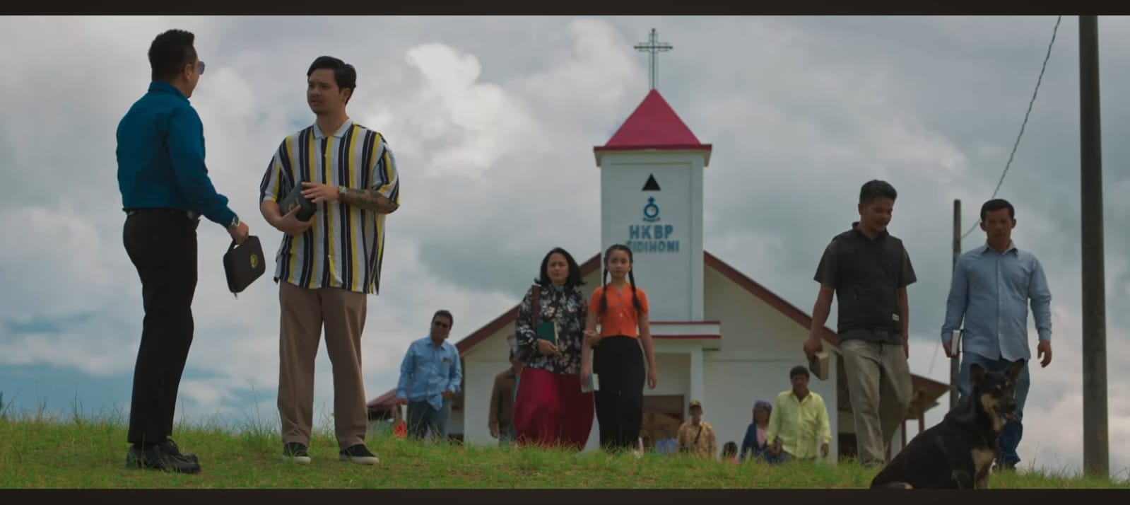 Poster film &ldquo;Wasiat Warisan&rdquo; menampilkan siluet keluarga di depan hotel tua, dengan bayangan Inang dan Algojo yang mengintai &mdash; visual kuat yang menggambarkan beban utang dan rahasia gelap.