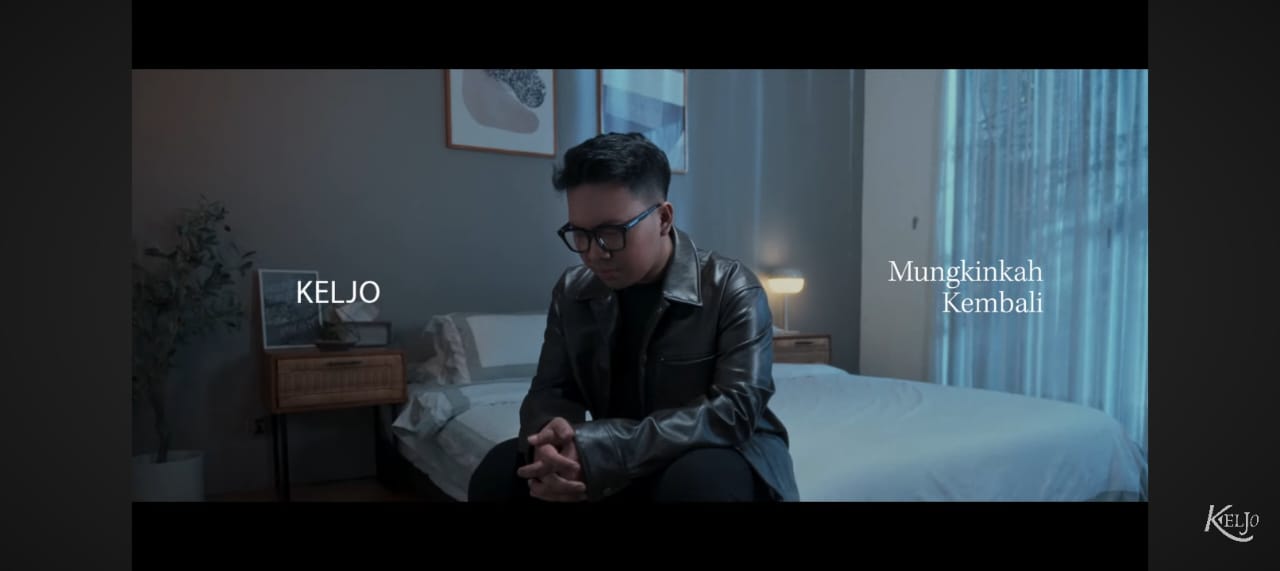 KELJO menatap kosong di balik cahaya redup &mdash; simbol penyesalan dan harapan dalam &ldquo;Mungkinkah Kembali.&rdquo;