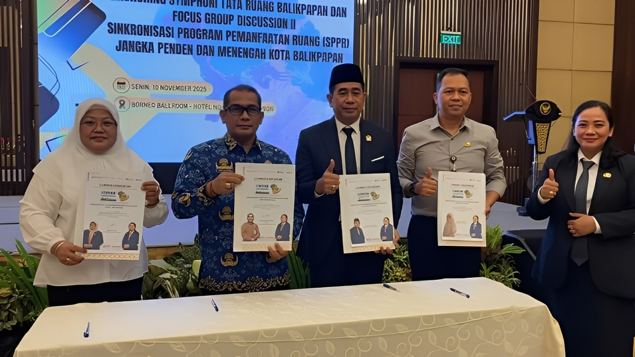 Wakil Ketua DPRD Balikpapan, Yono Suherman (peci), beserta jajaran berfoto bersama sambil menunjukkan dokumen saat peluncuran Program Symphoni Tata Ruang di Hotel Novotel, Senin (10 November 2025).