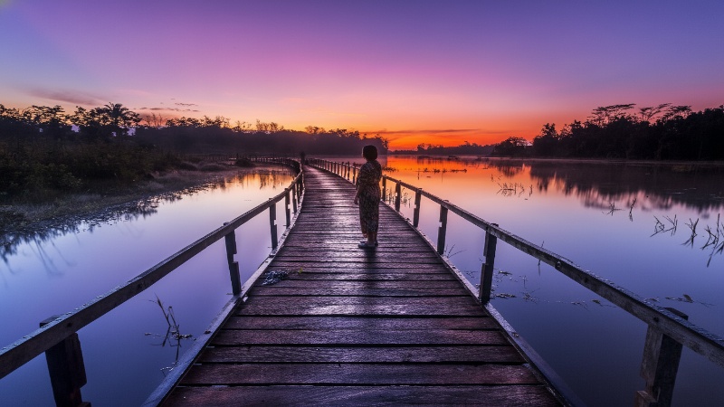 Panorama Waduk Manggar dengan hamparan air tenang, pohon hijau, dan dermaga kecil sebagai visual hook alami.