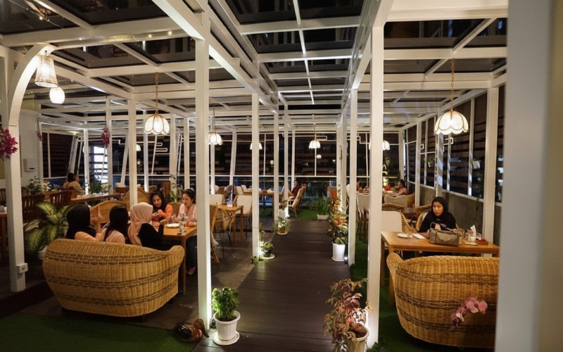 Interior Yellow Duck Cafe dengan dekor bebek kuning, tanaman hijau, dan cahaya hangat&mdash;visual estetik yang jadi daya tarik utama.