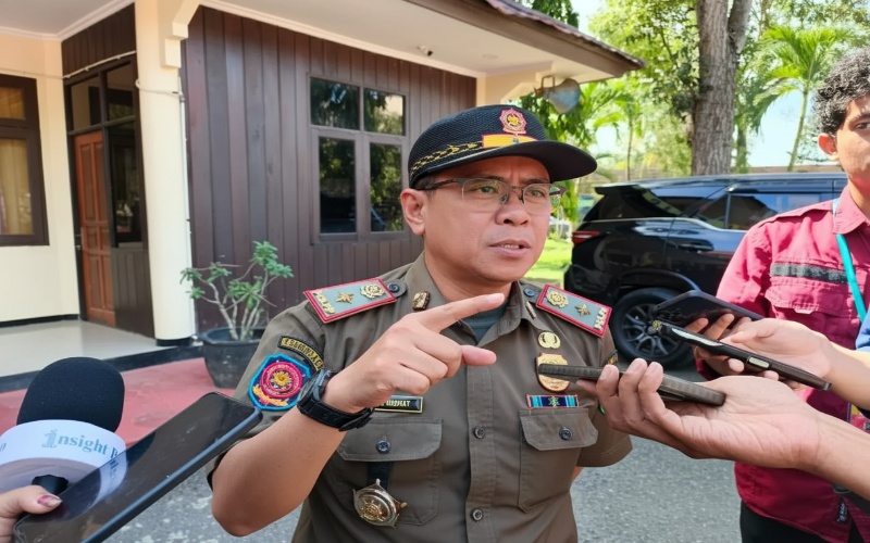Petugas Satpol PP Kutim melakukan sosialisasi di sekolah dengan latar Bukit Pelangi sebagai titik fokus pengawasan.