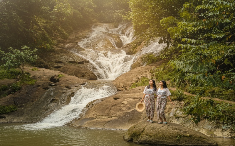 &ldquo;Air Terjun Pinang Seribu Samarinda &mdash; aliran air menyebar di bebatuan miring dengan suasana hutan tropis, visual adem yang memikat.&rdquo;
