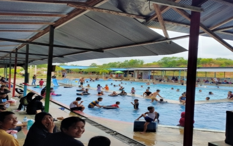 Suasana Kolam Renang Gunung Intan Babulu PPU dengan air jernih dan aktivitas keluarga, memberi visual segar dan natural.