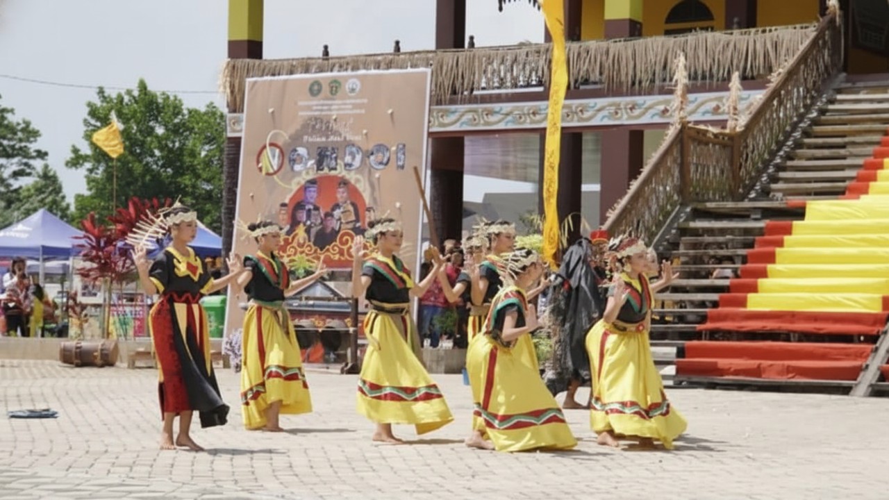 Penari Tari Nondoi Paser dengan kostum adat penuh detail, menari lembut dalam suasana penyambutan&mdash;visual hangat dan autentik.
